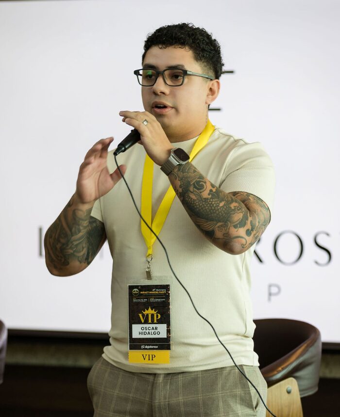 Oscar Hidalgo, founder of Vindex Consulting, speaking with a microphone at a business event
